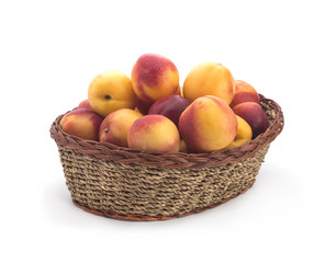 Ripe nectarines small, lying in a wicker basket