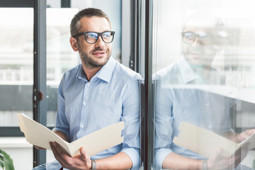 Joyous smiling man keeping papers