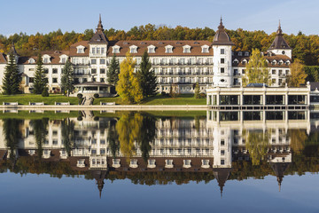Fototapeta na wymiar Facade of the tourist complex against the background of the lake and autumn park