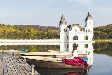 Girl in a boat on the background of the lake and autumn park