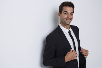 Smiling guy in business suit in white studio