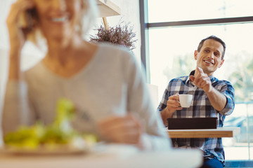 Delighted positive man sitting in the cafe