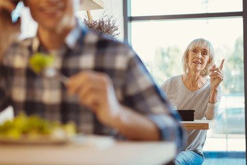 Nice elderly woman calling for a waiter