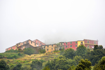 View to houses on mountains in a foggy day. Vernazza. Cinque Terre, Italy