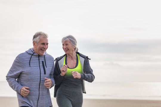 Senior Couple Jogging On Beach