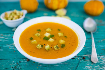 Delicious pumpkin soup with croutons on the wooden table. Vegetarian food. 