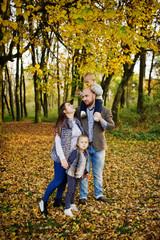Fototapeta premium Happy caucasian family of mom dad and little girl with boy at majestic autumn fall forest.