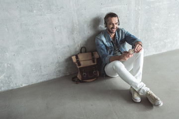 Fashionable adult guy is enjoying his playlist