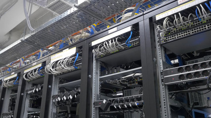Device for mining crypto currency. Row of bitcoin miners set up on the wired shelfs. Mining cryptocurrency. Bitcoin farm. Machines for mining cryptocurrency, bitcoin. Electronic device at day