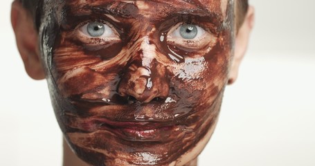 woman portrait with a chocolate facial mask on a white background