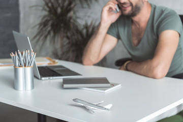 Cheerful young employee is talking on smartphone