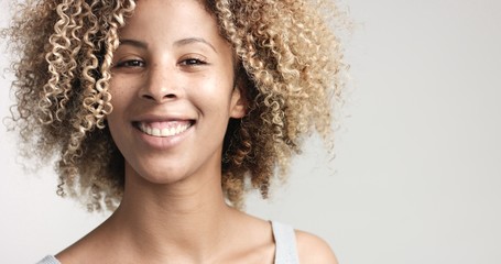 black woman with curly afro hiar and freckles portrait
