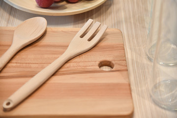 Wooden fork , spoon and plate on table.