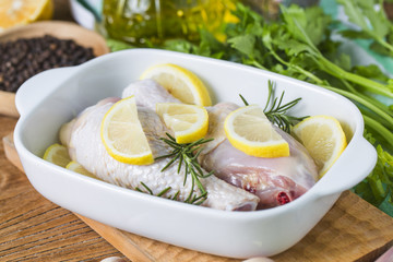 Raw uncooked chicken legs, drumsticks on wooden board, meat with ingredients for cooking