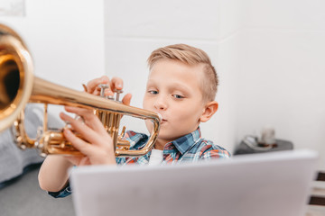 boy practicing trumpet