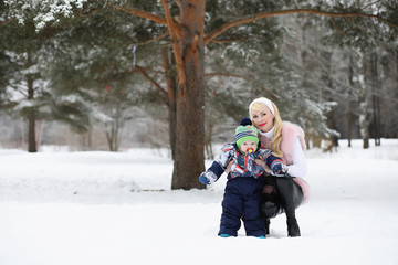 Young mother walks on a winter day with a baby in her arms in th