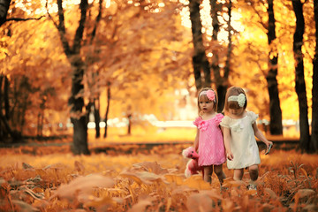 Fototapeta premium Mom with two daughters twins autumn