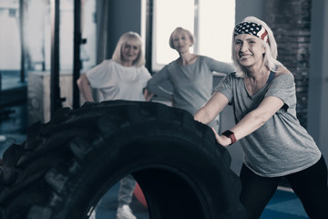 Obraz na płótnie Canvas Personal trainer showing tire exercises to her clients