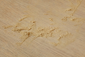 Heap of wood dust at a plank after sanding, woodwork