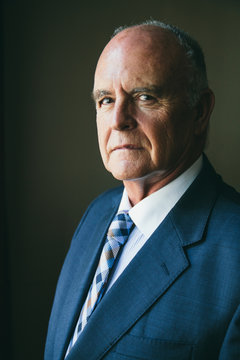 Senior businessman portrait on his office wearing a suit