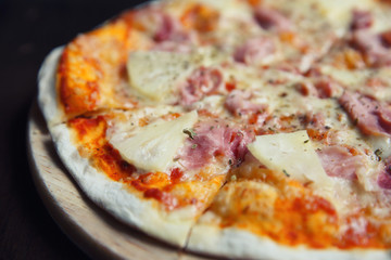 pizza hawaiian , pizza with pineapple and ham with cheese and tomatoes sauce on wood background , italian food
