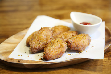 Fried chicken wings on wood background with restaurant light