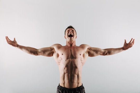Screaming young sportsman standing with opened hands