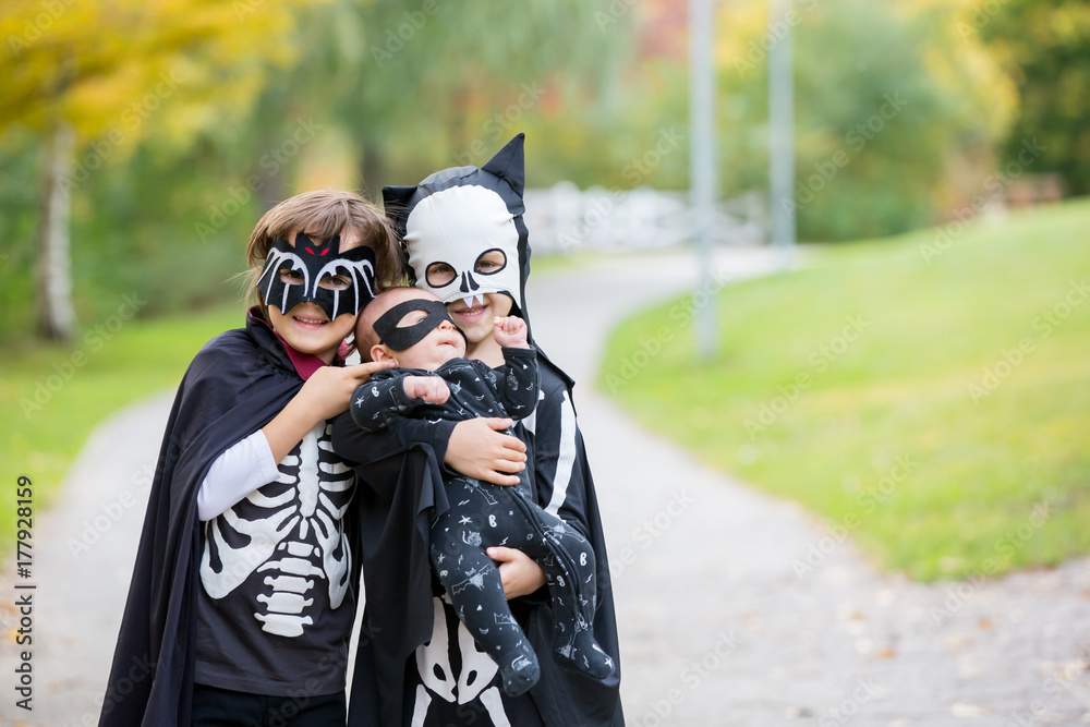 Wall mural Two children, boy brothers in the park with Halloween costumes