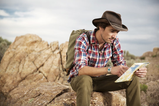 Guy Checking His Map While Backpacking