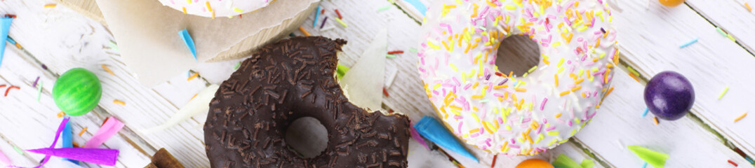 Horizontal bakground of donuts on a wooden