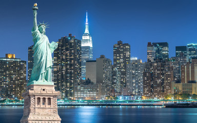 The Statue of Liberty with cityscape in Manhattan at night, New York City, USA