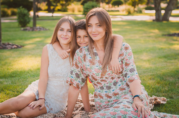 Happy family having fun in the summer at the park. Mom and children.