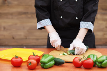 The cook cuts fresh farm vegetables