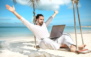Businessman freelance on beach with laptop - obrazy, fototapety, plakaty