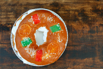 Spanish Christmas cake with fruits, nut and icing on wooden background