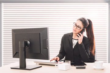 Portrait of a pretty secretary sitting at her desk