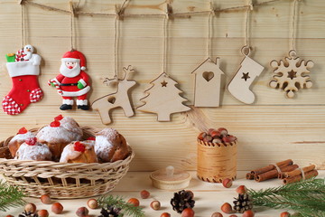 Christmas and New Year composition. Composition of Christmas and New Year decorations from plywood, a wicker basket with muffins, nuts and fir branches on a wooden background.