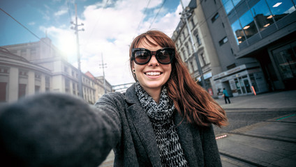 Smiling pretty woman selfie portrait at the city