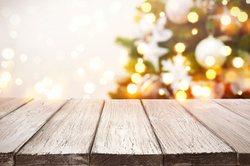 Christmas background. Wooden planks over blurred holiday tree lights