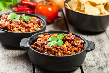 Bowls of hot chili con carne with ground beef, beans, tomatoes and corn