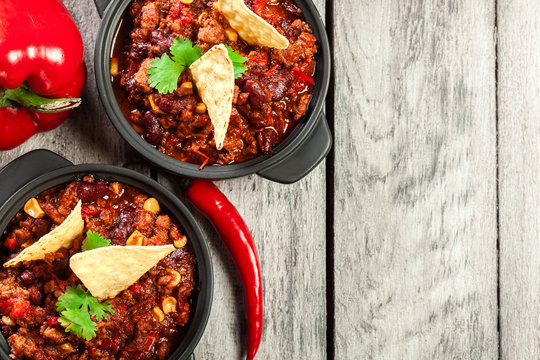 Bowls of hot chili con carne with ground beef, beans, tomatoes a