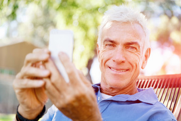 Obraz premium LoMature man outdoors using mobile phone