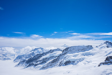 Fototapeta na wymiar Clear blue sky with the big cloud look like soft cotton candy on the top of the high mountain with snow cover