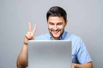 Happy young man video chatting on laptop computer
