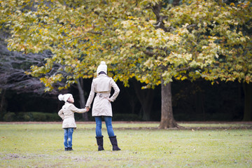 Fototapeta premium Mother and daughter playing in autumn park