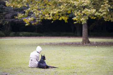 Doberman and women relax on the lawn