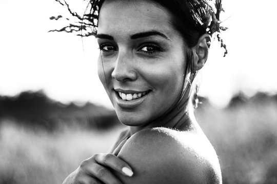 Black and white portrait of a beautiful young woman in sunny fields
