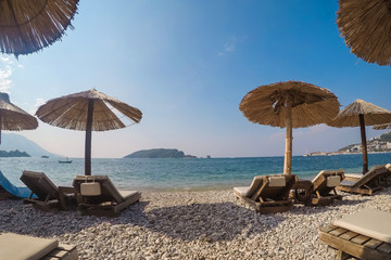 sunbeds and straw umbrellas on beach