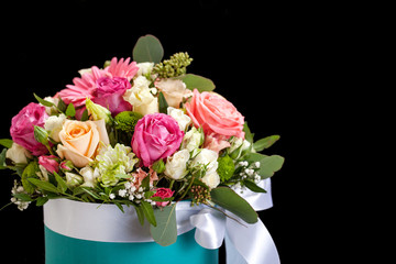 Bouquet of different flowers, roses, carnations, gerberas, sunflowers, irises, on a black background.