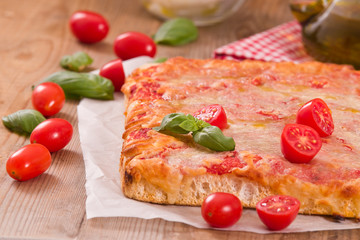 Italian pizza with cheese, tomatoes and fresh basil.
